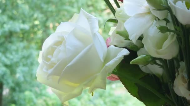 Witte roos en eustoma bloemen in boeket op wazig achtergrond - Video