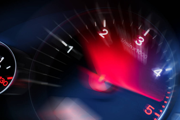 Bewegungsunschärfe einer Instrumententafel im Armaturenbrett Kilometerzähler mit rot beleuchtetem Anzeige.Tacho im Auto. Hochgeschwindigkeits-Tacho und Bewegung verschwimmen nachts. - Foto, Bild