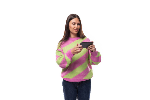Sähköisen liiketoiminnan käsite. 35-vuotias naisellinen malli nainen pukeutunut vaaleanpunainen ja vihreä pullover kellot video älypuhelimella. - Valokuva, kuva
