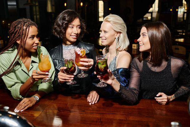 Barda kokteyl bardakları tutan neşeli çoklu etnik kadınlar, dost canlısı atmosferde eğlence. - Fotoğraf, Görsel