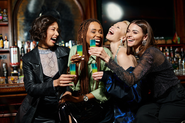 namoradas multirraciais alegres e na moda com óculos de tiro rindo no bar moderno, festa das galinhas - Foto, Imagem