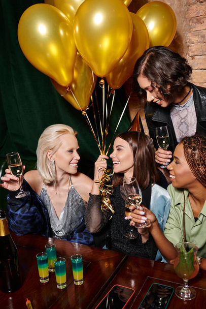 mulher feliz em chapéu de festa com balões dourados celebrando aniversário com namoradas multirraciais - Foto, Imagem
