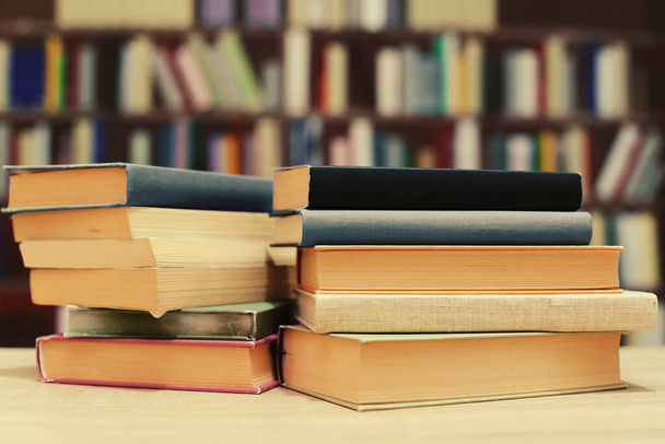 stos książek na drewnianym stole w bibliotece - Zdjęcie, obraz