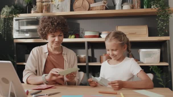 Slow motion shot of mother and daughter finishing making cute paper cat and dog masks and showing them to each other - Footage, Video
