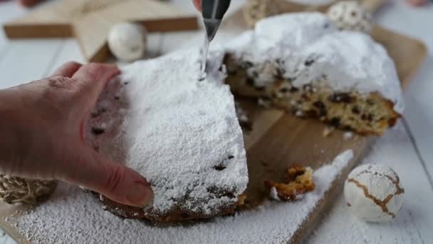 Cutting a slice of homemade Christmas stollen on a decorated table - Footage, Video