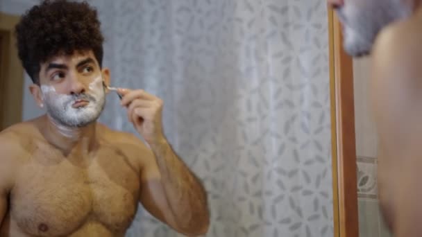 El hombre musculoso se afeita delante del espejo - 4K Horizontal video - Imágenes, Vídeo