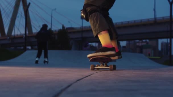 Молодая женщина в цветных носках Скейтбординг на обочине - вечер - Кадры, видео