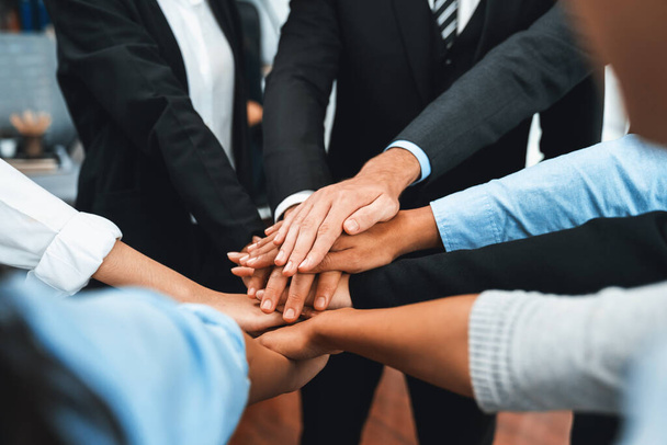 Multiracial business people make synergy hand stack together in meeting room as cooperation or team building for corporate employee in workplace. Meticulous - Photo, Image