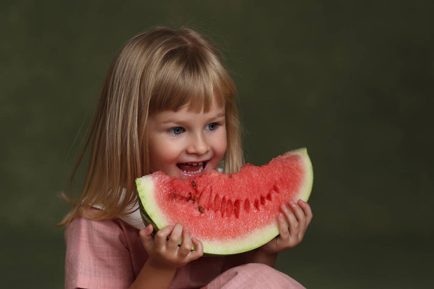 pieni tyttö syö mehukas vesimeloni. - Valokuva, kuva