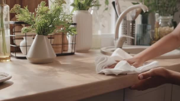 Κοντινό πλάνο slowmo της σύγχρονης καυκάσιας κοπέλας σκουπίζοντας πάγκο κουζίνας με λευκό πανί - Πλάνα, βίντεο