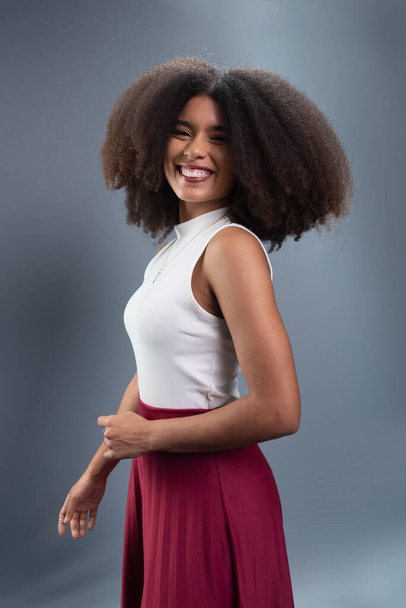 Gyönyörű fiatal nő, fekete hatalmi haj, álló, pózol egy fotó ellen szürke háttér. - Fotó, kép