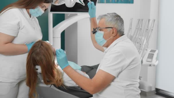 Ein Zahnarzt verwendet fortschrittliche Methoden und Materialien, um Zähne zu behandeln. Der Zahnarzt und sein Team dokumentieren den Behandlungs- und Genesungsprozess auf Video. Eine professionelle Zahnklinik sorgt für eine angenehme Atmosphäre - Filmmaterial, Video