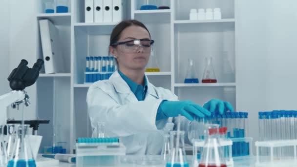 Στο εργαστήριο, ο επιστήμονας διεξάγει πειράματα με δείγματα, διερευνώντας τα χαρακτηριστικά τους και τις πιθανές ιδιότητές τους για την ανάπτυξη νέων ιατρικών τεχνολογιών. Υψηλής ποιότητας 4k - Πλάνα, βίντεο