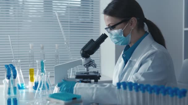 The investigator performs routine analyses, ensuring the stability and reliability of results in medical studies and chemical analyses. Woman worker doing laboratory work with microscope. High quality - Footage, Video