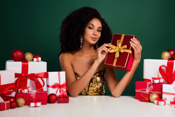 Zdjęcie eleganckiej pani promotor prezent pudełko specjalne oferta tylko na czas Bożego Narodzenia nad zielonym tle koloru. - Zdjęcie, obraz