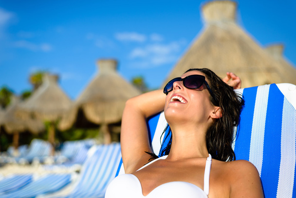 Woman on relaxing vacation at tropical resort beach sunbathing - Photo, image