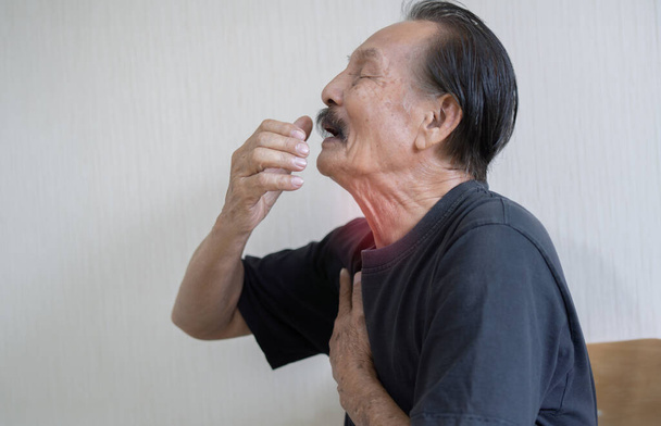 Портрет дорослого іспаномовного чоловіка в чорній футболці від кашлю хворіє. Проблеми з кашлем концепція. - Фото, зображення