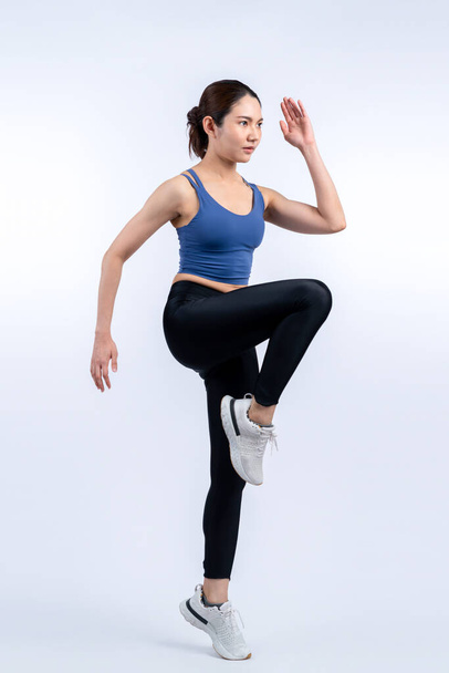 Вид збоку молода атлетична азіатка на біговій позиції в студії знімається на ізольованому фоні. В гонитві за здоровою фігурою тіла і кардіо вправами концепція способу життя. Яскравий - Фото, зображення