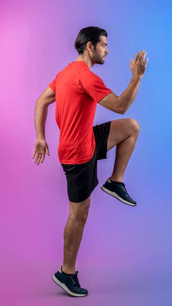 Full body length gaiety shot athletic and sporty young man fitness running cardio exercise posture on isolated background. Healthy active and body care lifestyle. - Photo, Image