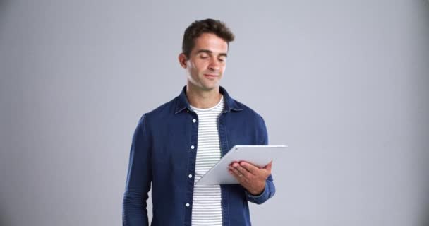 Happy, man and face with tablet in studio for social network, ebook subscription or streaming multimedia. Portrait, guy and digital technology to search, download or scroll website on grey background. - Footage, Video