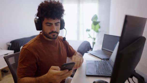 Vénézuélien garçon prend son téléphone portable pour jouer de la musique tout en travaillant à la maison - Vidéo horizontale 4K - Séquence, vidéo