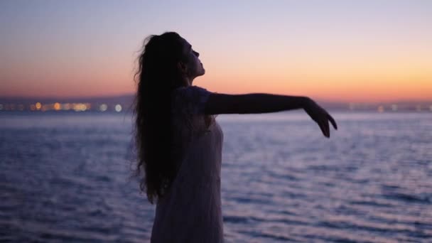 Доросла жінка відкриває руки, дивлячись на море - 4K Горизонтальне відео - Кадри, відео