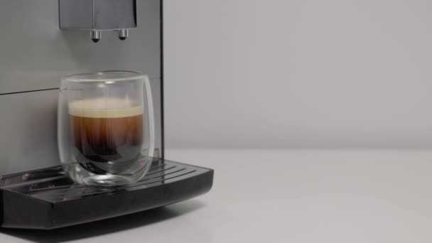 közeli-ból kávéfőző gép csinál eszpresszó és női kéz vesz egy csésze kávét - Felvétel, videó