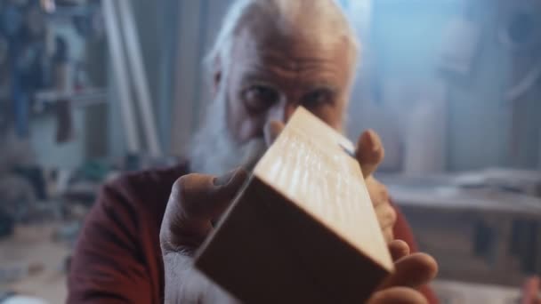 Selektiver Fokus mittlere Nahaufnahme des Tischlers, der seine Holzkreation auf Genauigkeit überprüft - Filmmaterial, Video
