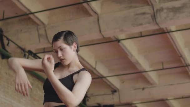 Alacsony szögben dönthető le lövés szenvedélyes fiatal kaukázusi női táncos csinál kecses kortárs tánc beltérben - Felvétel, videó
