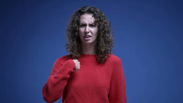 Заплутана жінка реагує на звинувачення з несподіванкою, вказуючи пальцем на себе, відкидаючи звинувачення - махаючи пальцем "не мене" мова тіла - Фото, зображення