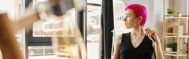 piękna młoda bizneswoman w stroju casual z tatuażami trzymając długopis i patrząc w bok, baner - Zdjęcie, obraz