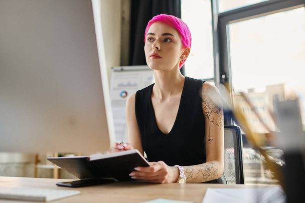giovane donna d'affari attraente con i capelli rosa e tatuaggi in abito casual urbano guardando il computer - Foto, immagini