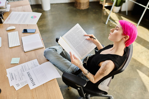 joven mujer de pelo rosa sentado en el escritorio con documento con palabra bancarrota en él, concepto de negocio - Foto, imagen