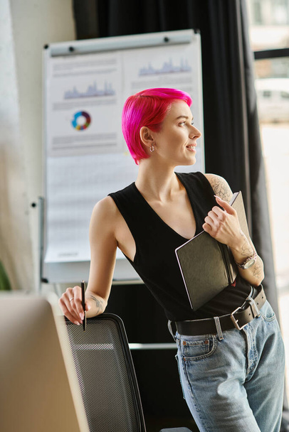 joyous pink haired businesswoman smiling happily and looking somewhere away with her notes in hand - Photo, Image
