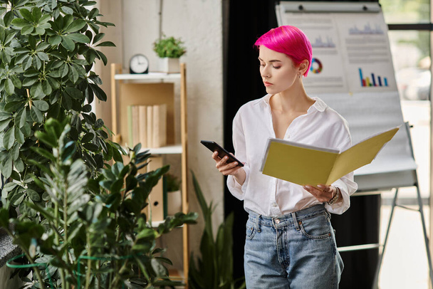 young attractive female worker in white shirt holding notes and looking at her phone, business - Foto, Imagen
