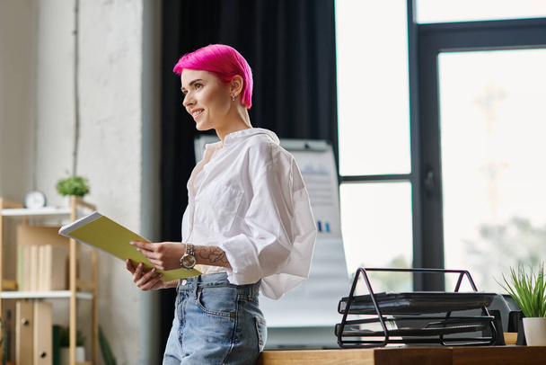 весёлая привлекательная работница, держащая свои заметки в офисе и счастливо улыбающаяся, бизнес-концепция - Фото, изображение