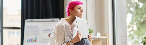 Nachdenkliche junge Geschäftsfrau in weißem Hemd sitzt und hält ihren Laptop im Büro, Transparent - Foto, Bild