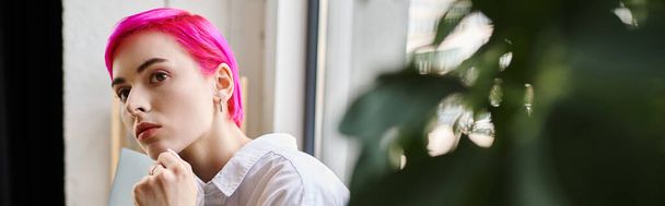 στοχαστική επιχειρηματίας σε casual ενδυμασία με ροζ μαλλιά που ποζάρει στο γραφείο και κοιτάζει αλλού, banner - Φωτογραφία, εικόνα
