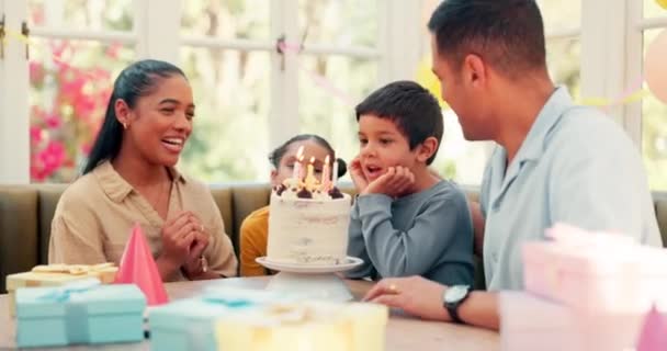 Születésnapi torta, család és boldog gyerek fúj gyertya láng ifjúsági ünneplés, szórakoztató otthoni party vagy izgatott csoportos esemény. A szülők szeretik, édességet és kisgyermek mosoly, boldogság és éljenzés a különleges nap. - Felvétel, videó