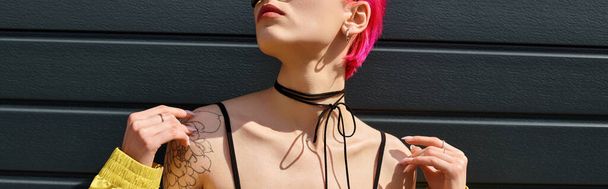 jovem de cabelos rosa em óculos de sol amarelos e roupa elegante posando na rua urbana, banner - Foto, Imagem