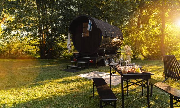 Barril de sauna de madeira finlandês com uma mesa com comida fresca e - Foto, Imagem