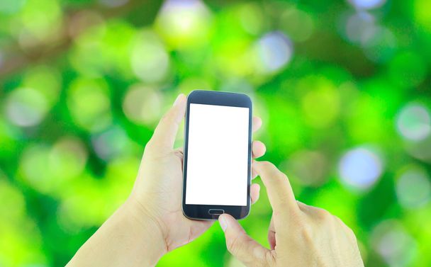 Mano sosteniendo teléfono inteligente aislado en abstracto verde bokeh backgr
 - Foto, Imagen