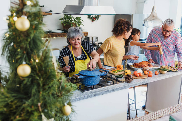 Lateinamerikanische Familie kocht gemeinsam zu Hause in Mexiko Lateinamerika für das Weihnachtsessen, hispanische Leute Mutter, Großeltern und Tochter bereiten Putenfleisch in den Ferien zu - Foto, Bild
