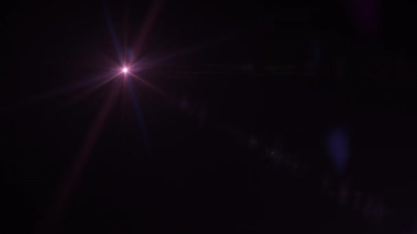 Abstracte veelkleurige optische lens flares schijnen licht barsten animatie op zwarte achtergrond. 4K dynamisch kinetisch heldere ster licht stralen effect.  - Video