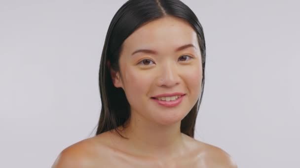 Japanese woman, face skincare and studio with smile, laughing and cosmetics by white background. Happy Asian girl, young model and makeup with beauty, wellness and self care with natural aesthetic. - Footage, Video