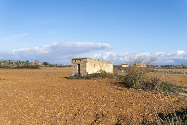 Ogólny widok na krajobraz ze starym opuszczonym wiejskim domem, we wnętrzu wyspy Majorka w słoneczny poranek. Felanitx, wyspa Majorka, Hiszpania - Zdjęcie, obraz