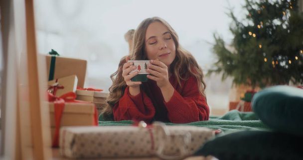 Mujer sosteniendo la taza de café caliente disfrutando de las vacaciones de Navidad - Foto, Imagen