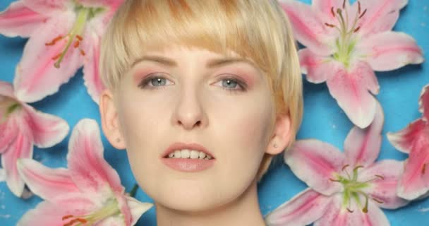 Schoonheid vrouw op blauwe achtergrond met bloem - Video