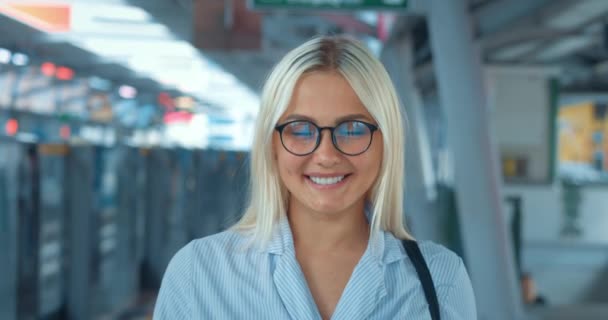 Portrét usměvavé ženy v metru. Happy spokojen rád pěkný mladý milennial kavkazský blondýnka žena v brýlích s úsměvem zářící štěstím radost při pohledu na kameru proti metra - Záběry, video