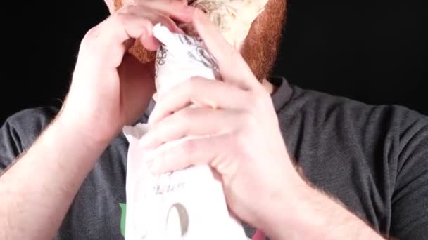 Punapartainen mies syö burritoa, lähikuva - Materiaali, video